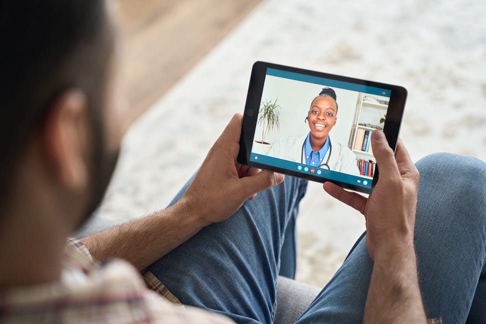 Un homme en vidéoconférence sur sa tablette avec un médecin.