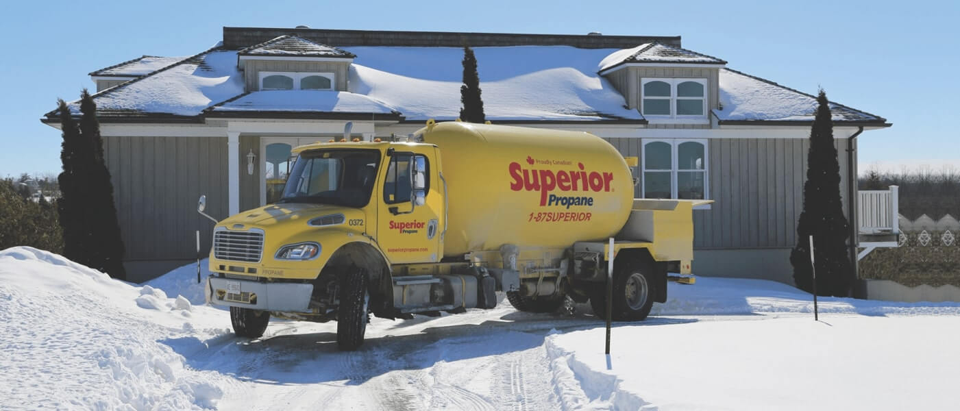 Camion de Supérieur Propane effectuant une livraison à une maison résidentielle, au beau milieu de l'hiver.