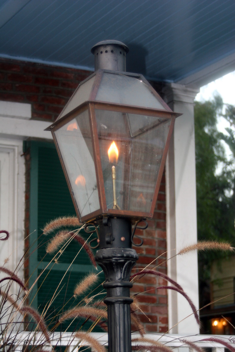 Lampe au propane devant une maison en brique