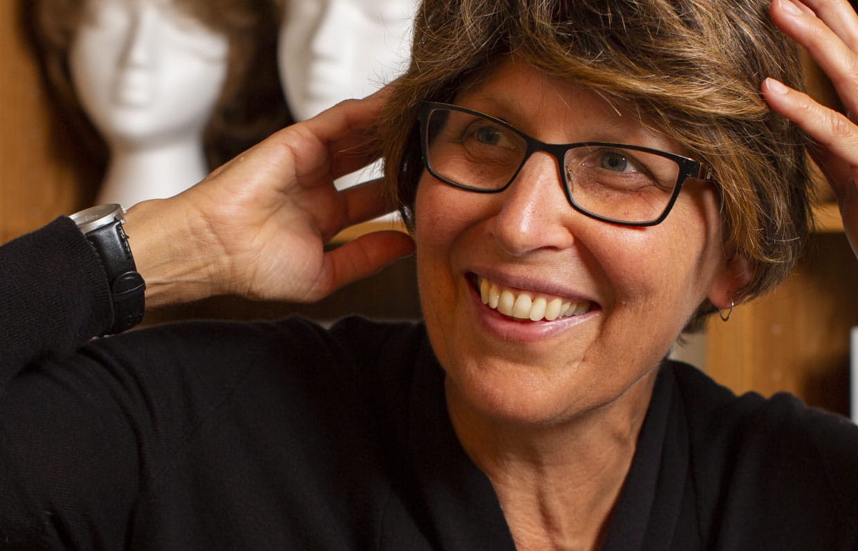 Une cliente souriante de la banque de prothèses capillaires portant une nouvelle prothèse.