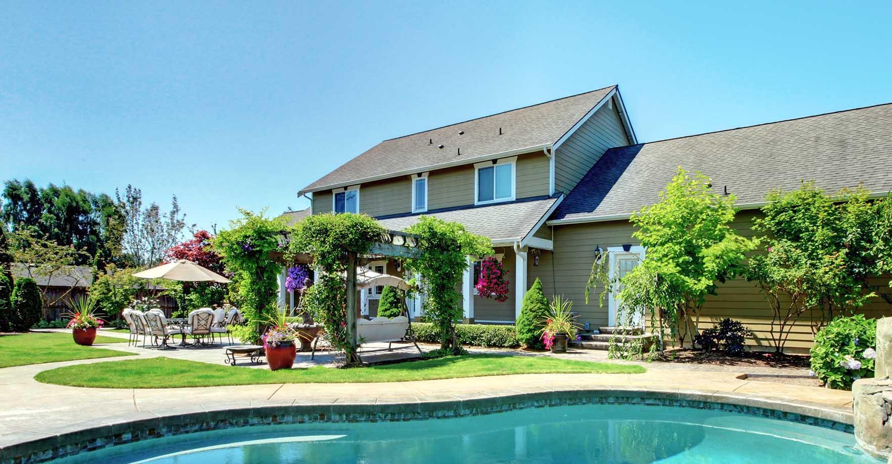 Cour arrière d'une résidence chauffée et alimentée au propane. Il y a une piscine, une terrasse et une pergola.