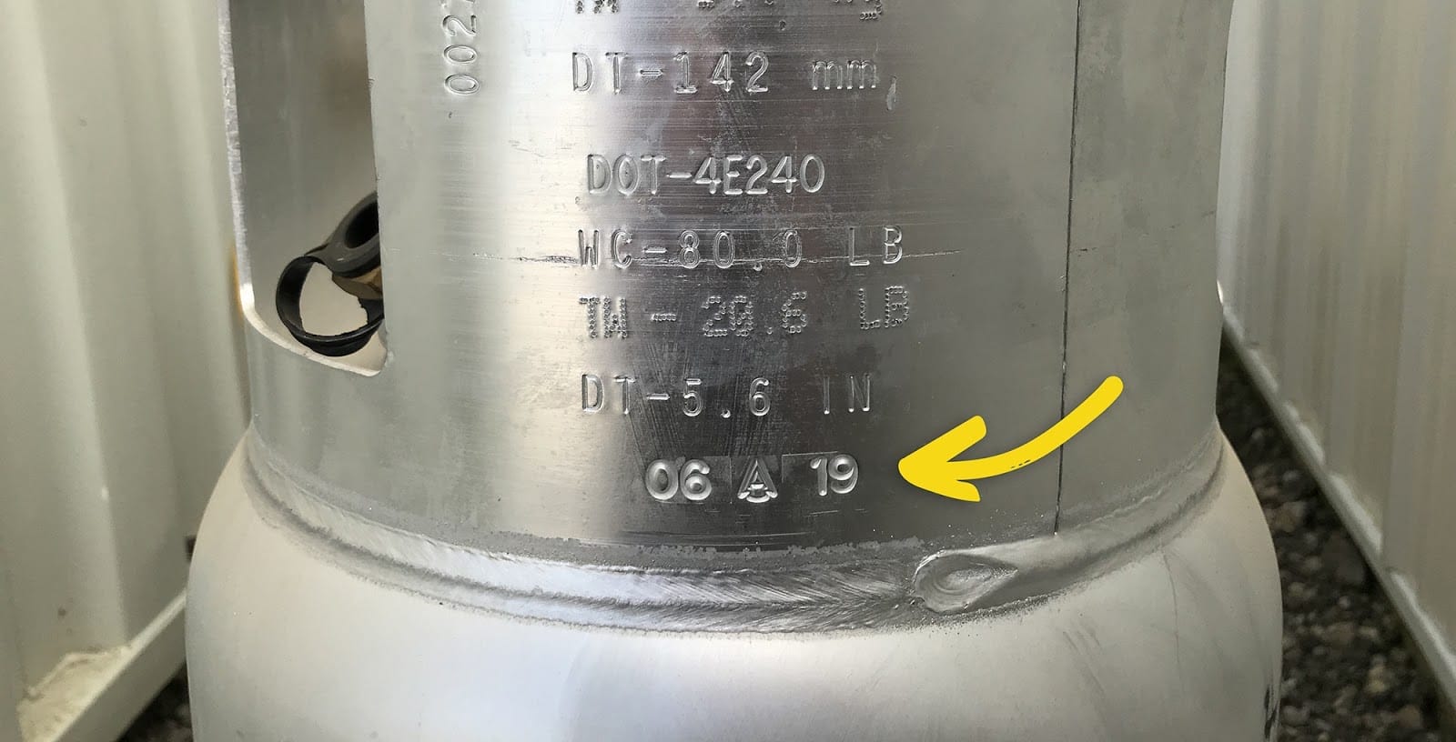 Gros plan d'un collet du réservoir de propane avec une flèche pointant vers la date du fabricant.
