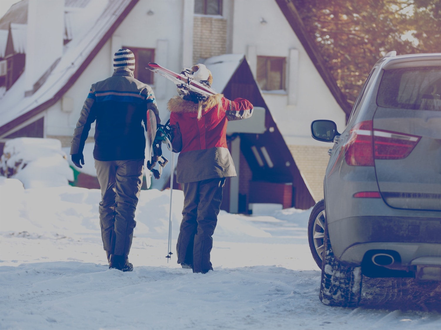 Un couple marche du stationnement vers une station de ski.