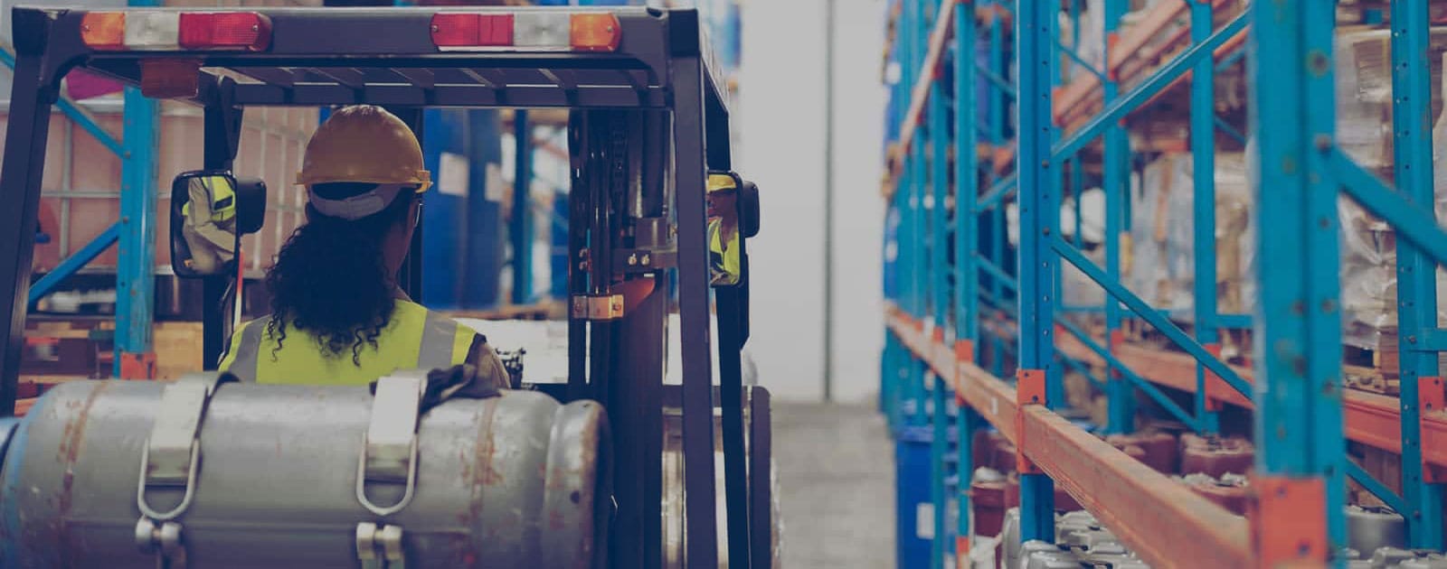 Un chariot à fourche au propane traversant un entrepôt.