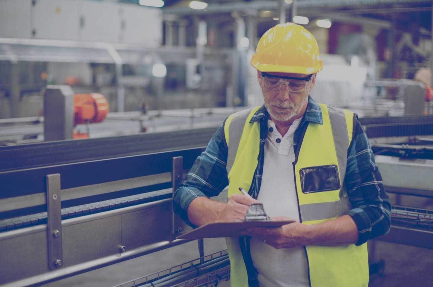 Un travailleur de la construction inspectant la zone de travail et écrivant sur un presse-papiers.