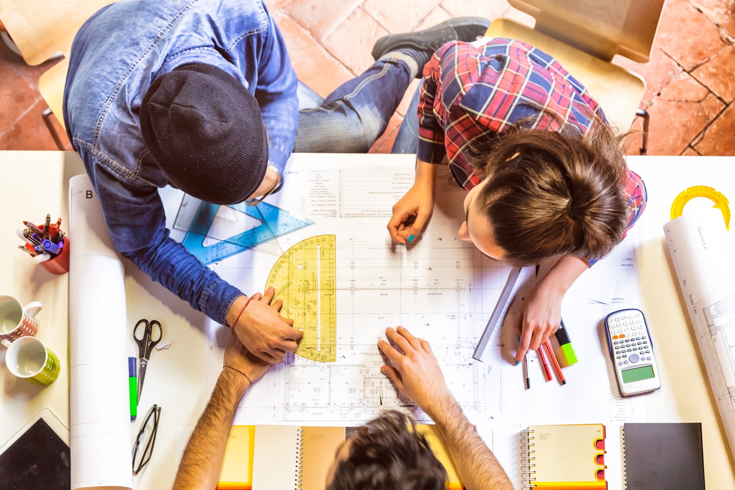 Trois personnes travaillant au design d'une nouvelle maison pour maximiser l'utilisation du propane.