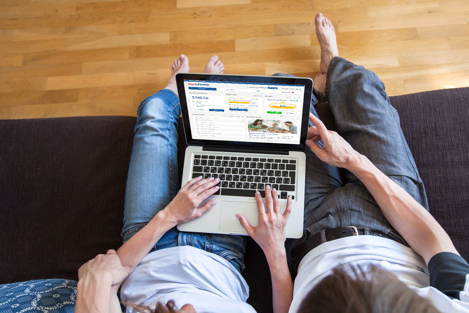 Couple assis sur un divan, regardant le site Web monSUPÉRIEUR, sur un ordinateur portatif