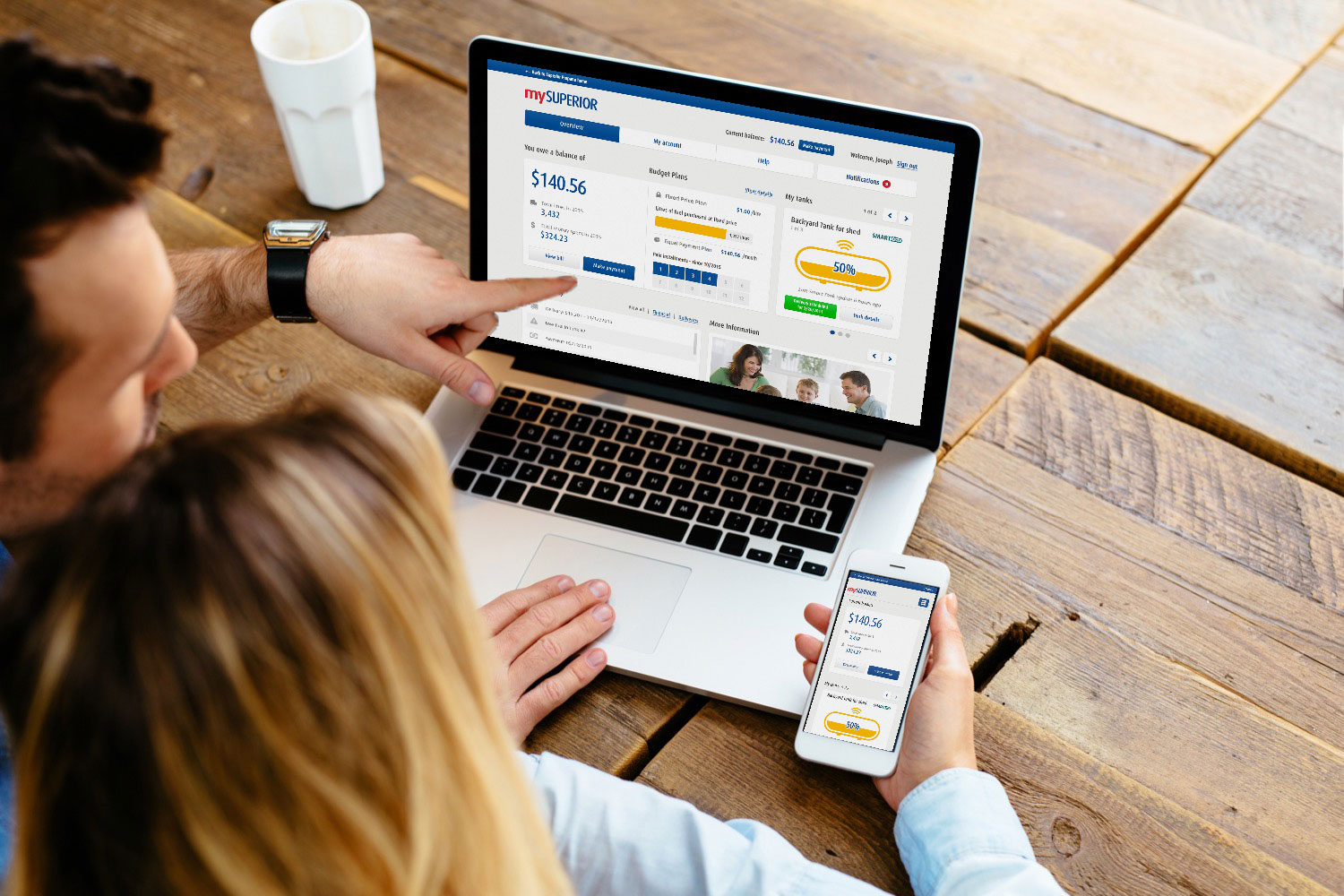 Couple regardant monSUPÉRIEUR sur un ordinateur portatif et sur un cellulaire.