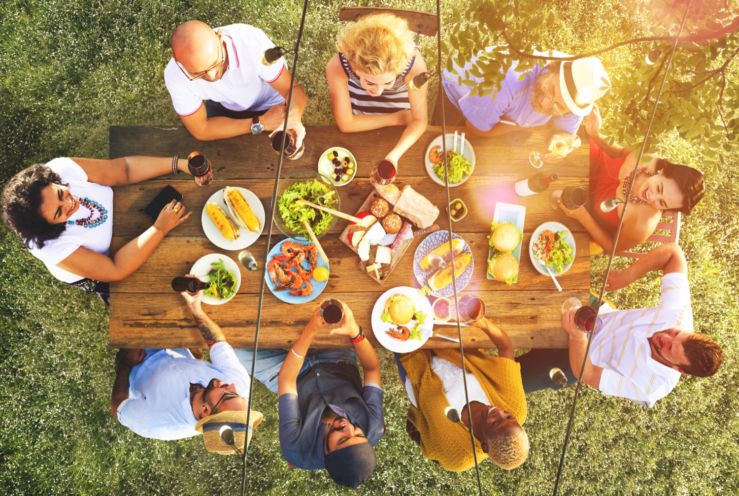 Une vue aérienne d'un groupe d'adultes partageant un gros repas sur une terrasse chauffée au propane.