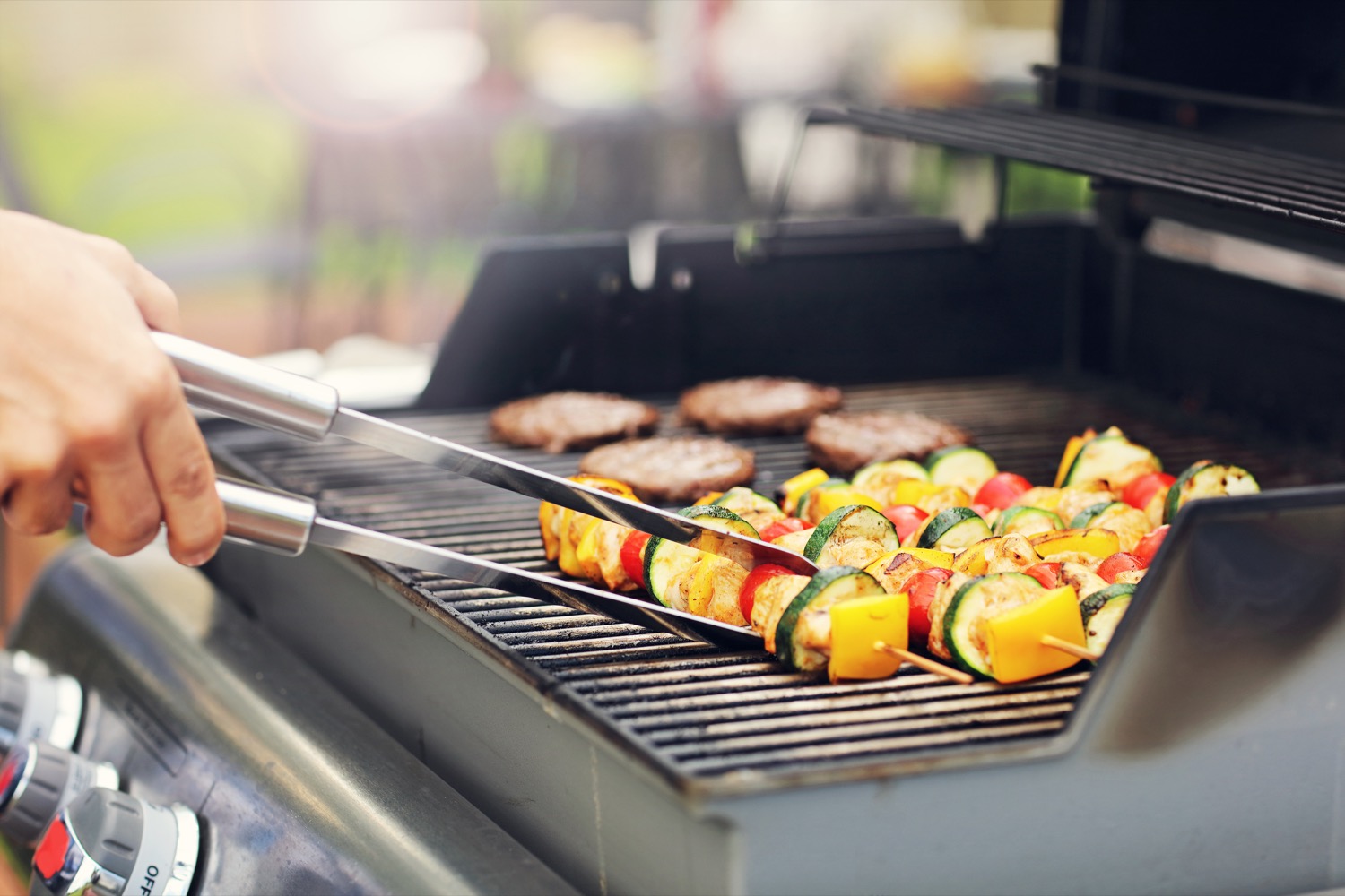 Cuisson de kébabs végétariens et de burgers sur un gril de barbecue alimenté au propane.