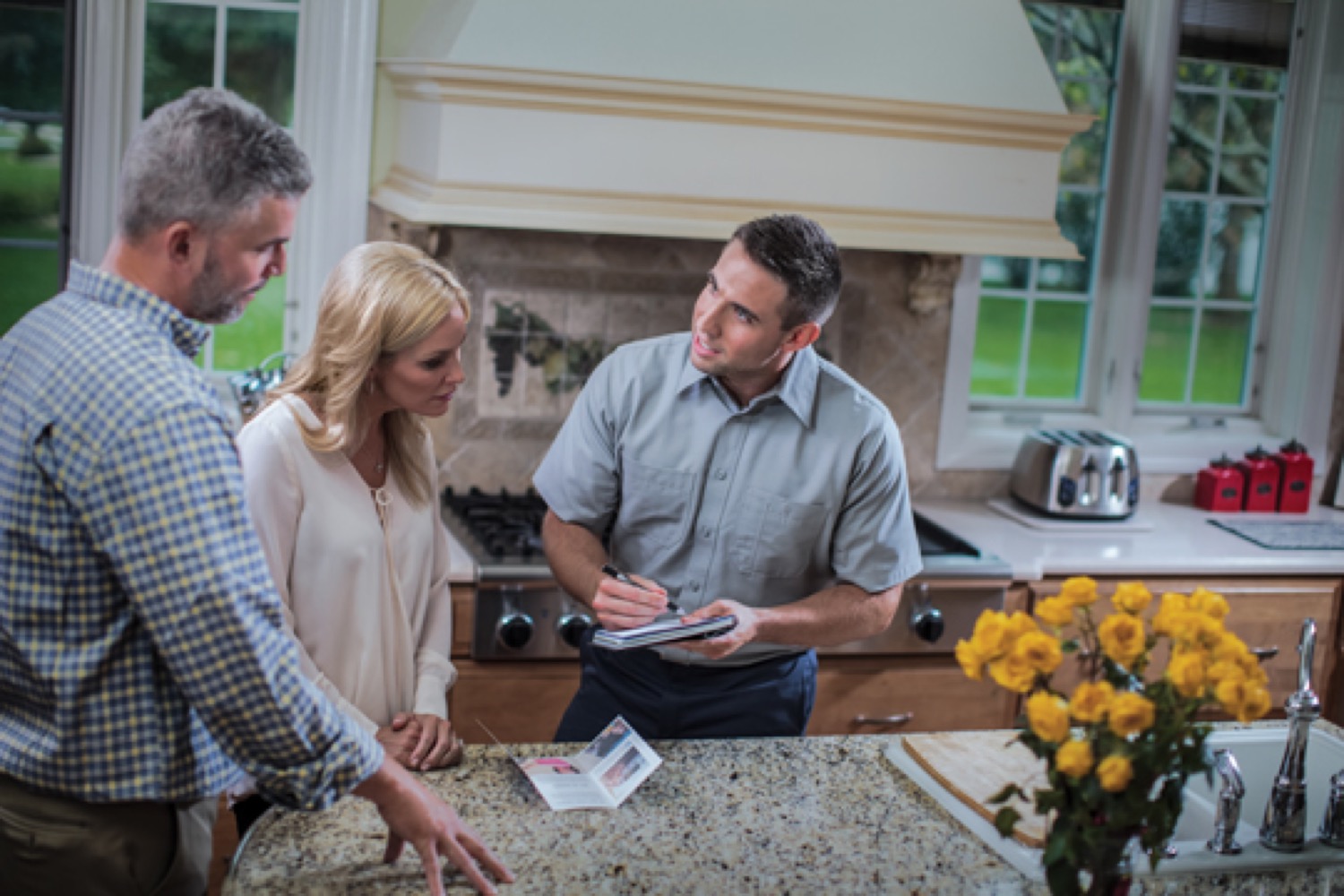 Employé de Supérieur Propane ayant une conversation avec un couple dans une cuisine