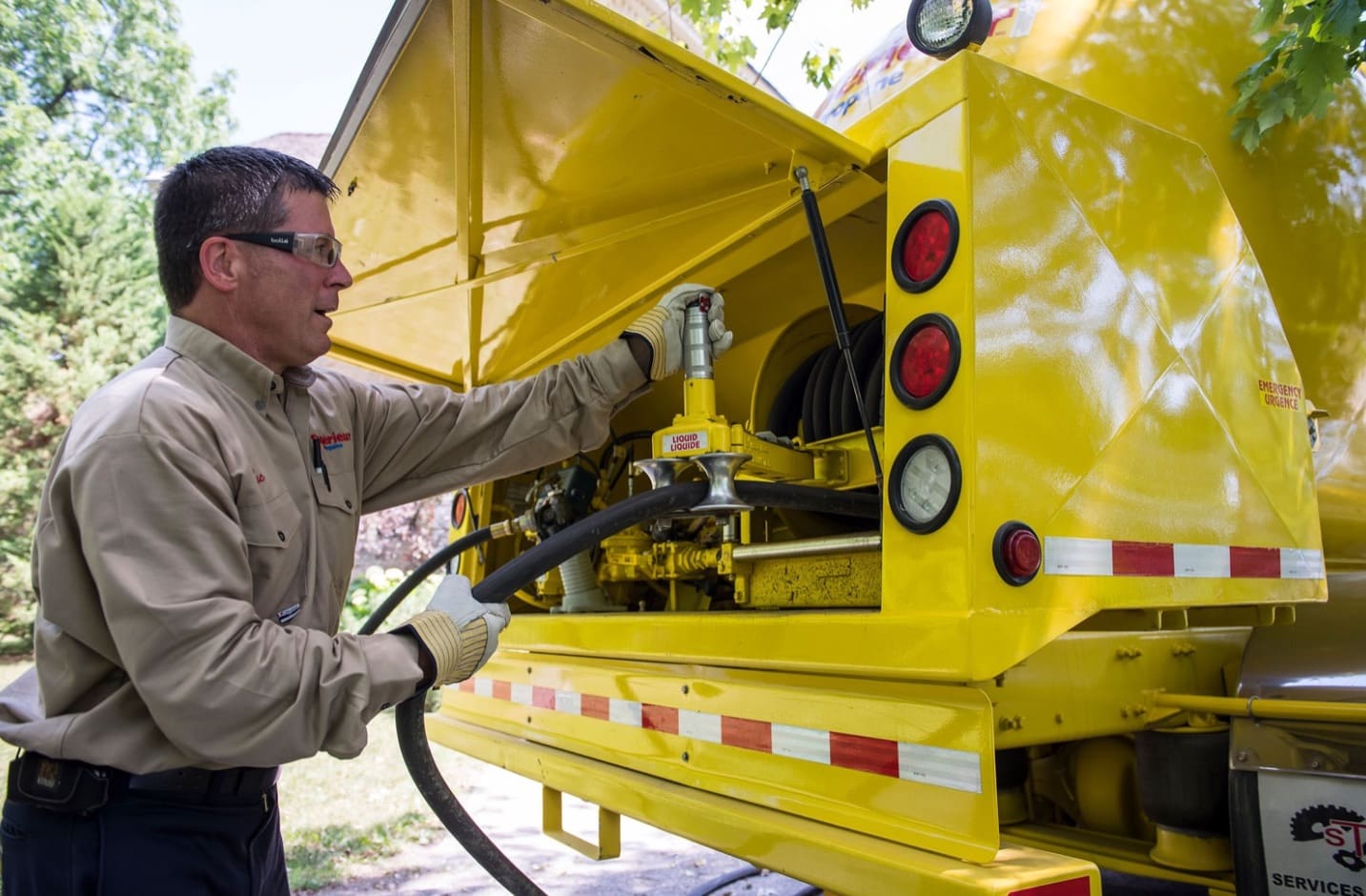 Un employé de Supérieur Propane prépare le tuyau du camion pour commencer à remplir un réservoir.