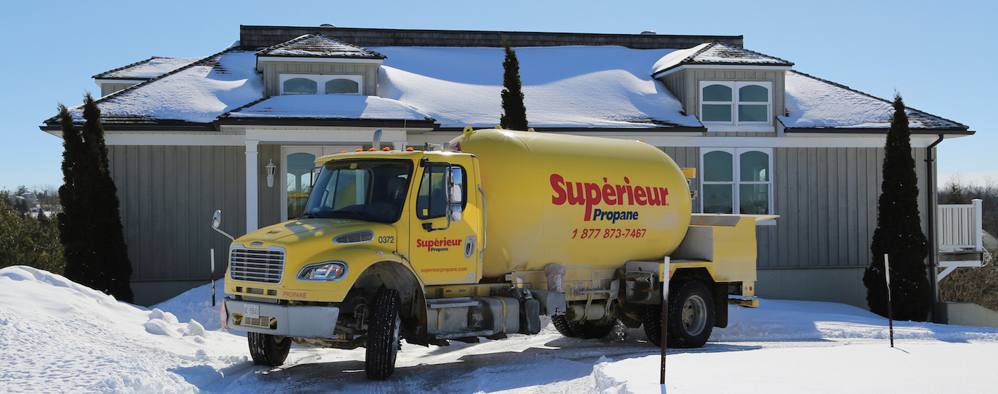 Camion de Supérieur Propane effectuant une livraison à une maison résidentielle, au beau milieu de l'hiver.