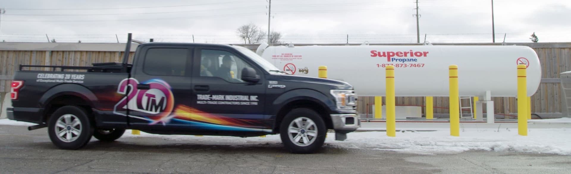 Un camion de Trade-Mark stationné devant un réservoir de 2 000 gallons