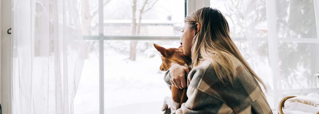 une femme regardant par la fenêtre en hiver