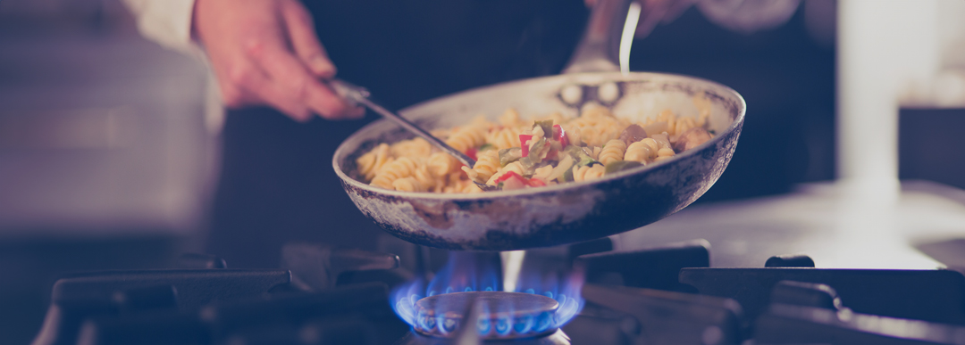 Plan rapproché d'un chef cuisinant sur une cuisinière